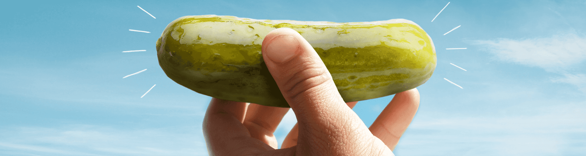 A hand holding a pickle